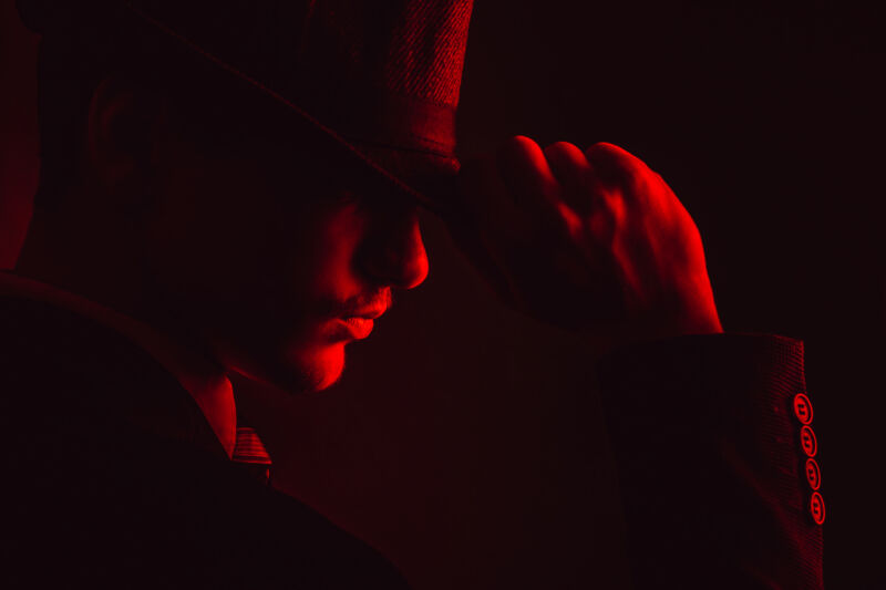 Man wearing fedora in red light